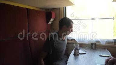 火车车厢里的一个男人听着耳机里的音乐在送信者社交中留言的剪影